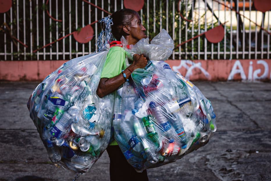 Catador carrega sacolas de materiais recicláveis